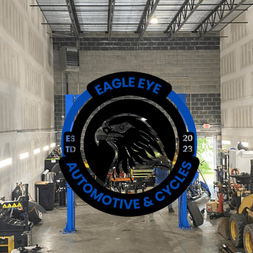 Interior of a garage with 'Eagle Eye Automotive & Cycles' logo featuring an eagle.